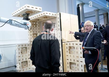 Prime Minister Boris Johnson operating a robot arm at the Auar (Automated Architectire) stand during a visit to the Innovation Zone of the Global Investment Summit at the Science Museum, London. Picture date: Tuesday October 19, 2021. Stock Photo