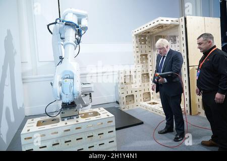 Prime Minister Boris Johnson operating a robot arm at the Auar (Automated Architectire) stand during a visit to the Innovation Zone of the Global Investment Summit at the Science Museum, London. Picture date: Tuesday October 19, 2021. Stock Photo