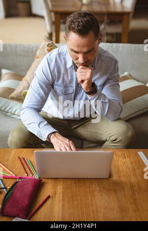 Caucasian man using laptop sitting on the couch at home Stock Photo