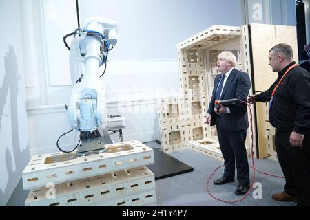 Prime Minister Boris Johnson operating a robot arm at the Auar (Automated Architectire) stand during a visit to the Innovation Zone of the Global Investment Summit at the Science Museum, London. Picture date: Tuesday October 19, 2021. Stock Photo