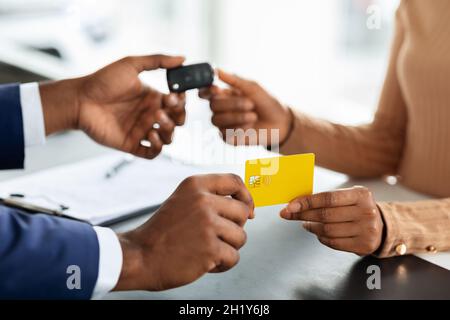 Buying Auto. Woman Giving Credit Card To Salesperson And Taking Car Keys Stock Photo