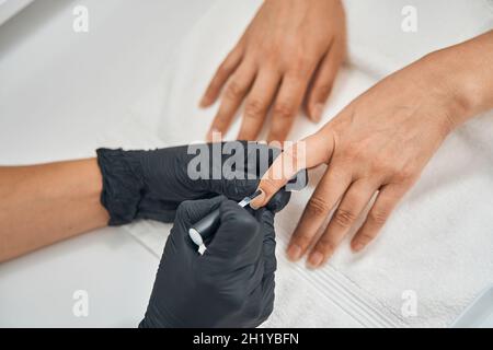 Focused photo on female hand applying polish Stock Photo