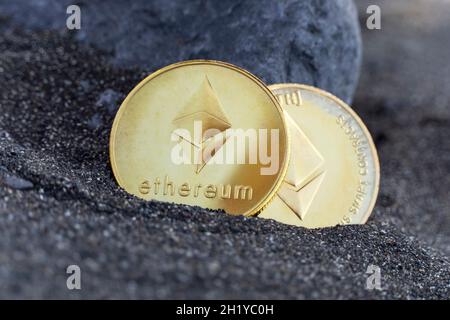Two coins of the digital currency Ethereum in the sand Stock Photo