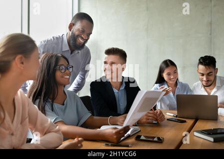 Portrait Of Smiling Young Business People Communicating During Corporate Meeting In Office Stock Photo