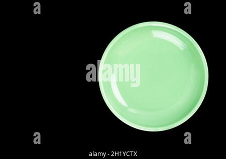 Empty green ceramic plate on black background Stock Photo