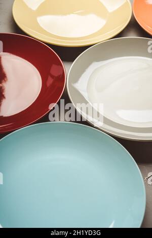 Clean different colour plates on the rustic background. Selective focus. Stock Photo