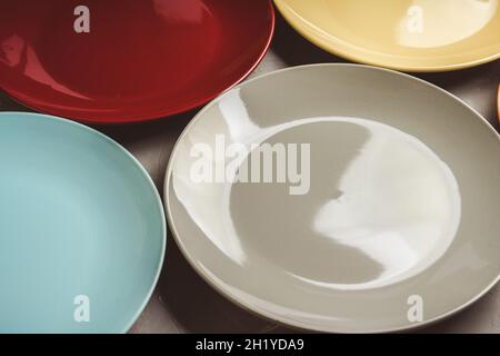Clean different colour plates on the rustic background. Selective focus. Stock Photo