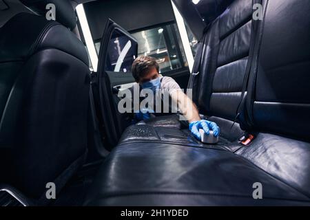 Man with sponge cleaning car seats surface Stock Photo