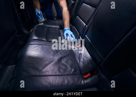 Worker dry-cleaning car seats during valeting service Stock Photo