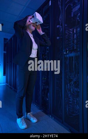 Female in VR glasses working at data center Stock Photo