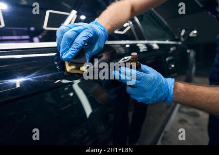 Person applying coating on car surface scratches Stock Photo