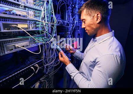 System administrator doing diagnostic tests on computer servers Stock Photo