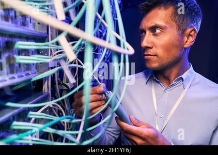 Sysadmin doing performance testing of network cabling Stock Photo