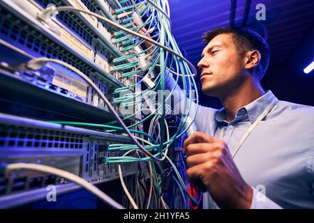 Engineer testing cable connections on network server Stock Photo