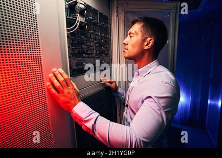 Serious concentrated IT technician inspecting hardware equipment Stock Photo