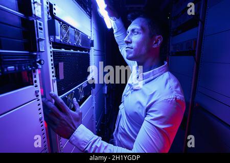 Experienced serious system administrator monitoring network server Stock Photo