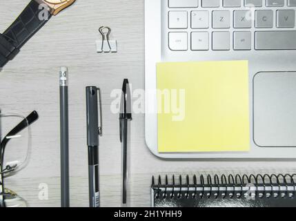 Working desk with a wristwatch, glasses, pens, notebook, clip, and laptop - work from home concept Stock Photo