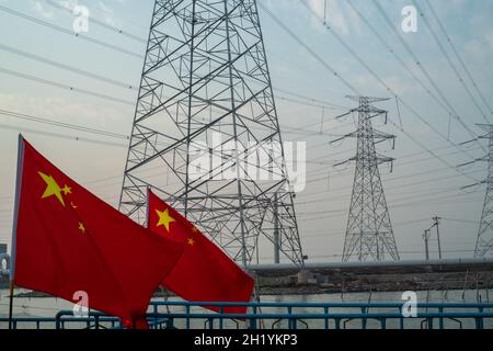 Chinese flag waving in front of high-voltage transmission towers in Tianjin, China. 19-Oct-2021 Stock Photo