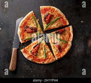 Pizza Margherita with asparagus and aubergines on a baking tray Stock Photo