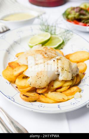 Fried fish with fried potatoes and mushroom sauce Stock Photo