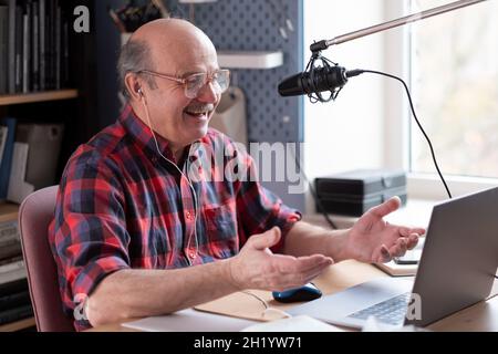 Smiling old elder grandfather talking to webcam on video chat sit at home Stock Photo