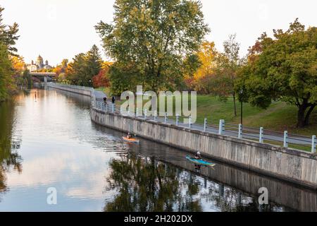 Ottawa, Canada - October 11, 2021: Rideau Canal, Hog's Back Locks in Ottawa, Canada. Autumn season in park with road along the river in the evening Stock Photo
