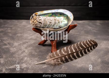 A close up image of a white sage bundle in an abalone shell. Stock Photo