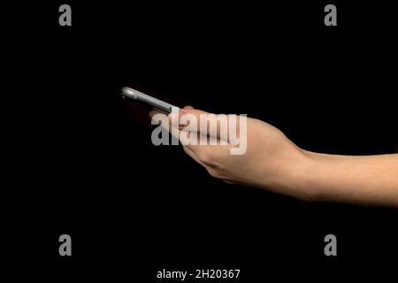Close-up of hand using mobile phone against black background photo Stock Photo