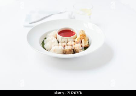 Various types of dim sum on a plate with a dip Stock Photo