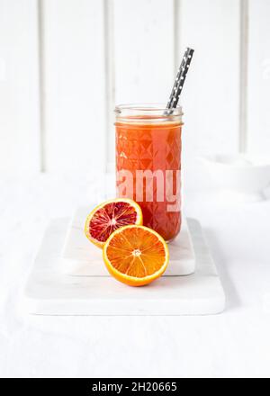 Freshly squeezed blood orange juice in glass with drinking straws Stock Photo