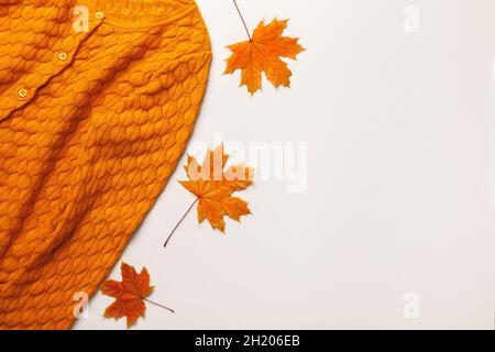Autumn concept. Yellow-orange sweater with maple leaves on a light gray background. Flat lay top view copy space Stock Photo