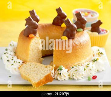 Savarin for Easter with cream, mini chocolate bunnies and colourful Easter eggs Stock Photo