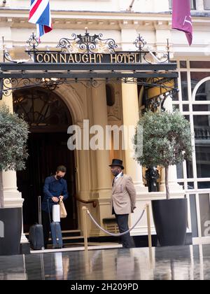 The Connaught five star luxury hotel, located in Mayfair, London. The hotel is owned and managed by Maybourne Hotel Group.  Doorman porter is seen greeting customers Stock Photo