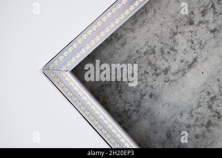 Strip LED light with square aluminum profile. Stretch ceiling with LED lighting in residential building, indoor photo, close up. Home renovation conce Stock Photo
