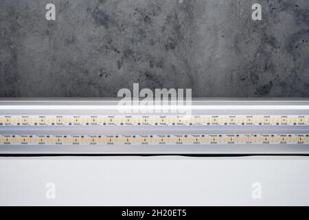 Strip LED light with aluminum profile. Stretch ceiling with LED lighting in house or apartment, indoor, close up. Home renovation concept. Energy savi Stock Photo