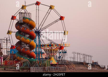 slide and Ferris wheel at Cleethorpes seaside resort, East coast of England, at sunrise Stock Photo