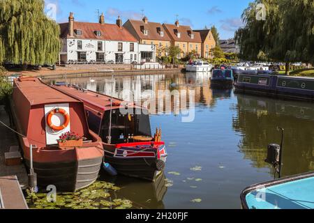 Narrowboats moored on the Great Ouse River with Cutter Inn and riverside properties in Ely Cambridgeshire England Stock Photo