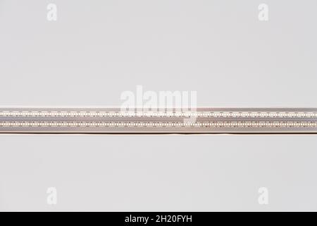 Strip LED light with aluminum profile on white stretch ceiling in house or apartment, indoor close up. Home renovation concept. Modern construction, e Stock Photo