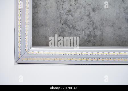 Strip LED light with square aluminum profile. Stretch ceiling with LED lighting in residential building, indoor photo, close up. Home renovation conce Stock Photo