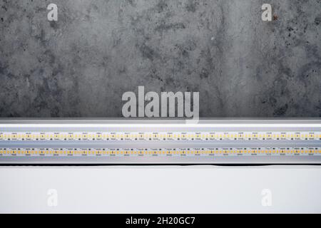 Strip LED light with aluminum profile. Stretch ceiling with LED lighting in house or apartment, indoor, close up. Home renovation concept. Energy savi Stock Photo