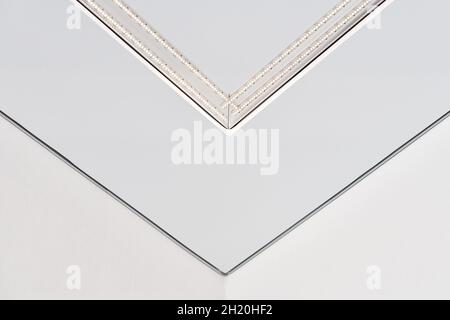 Strip LED lamp lighting with square aluminum profile on suspended ceiling in house, fragment, close up. Home renovation concept and remodeling. Energy Stock Photo