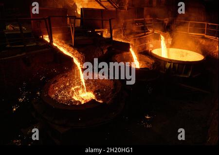 Blast furnace slag and pig iron tapping. Molten metal and slag are poured into a ladle. Stock Photo