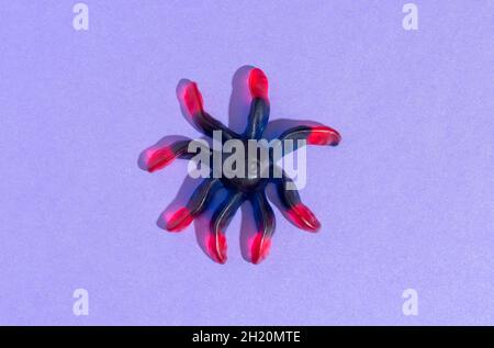 Gummy sweet spider on a purple background. Halloween Stock Photo