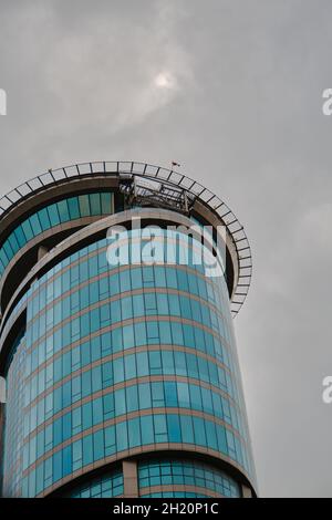 modern architecture type of skyscraper building in istanbul during overcast clouds and rain day with its windows made of glass material. Stock Photo