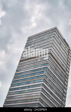 modern architecture type of skyscraper building in istanbul during overcast clouds and rain day with its windows made of glass material. Stock Photo