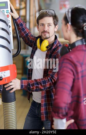 engineer training female apprentice on machine Stock Photo