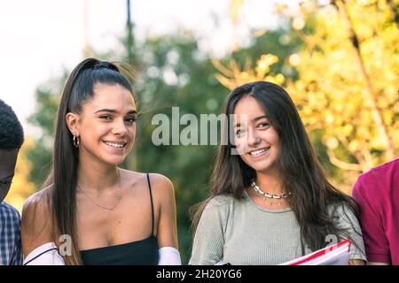 Two young woman facing the camera while standing in a park Stock Photo