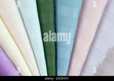 Bed linen fabric samples. Beautiful high-quality fabric for sewing bed linen. Samples of color stripe satin background. Cotton textiles of white, gree Stock Photo