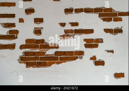 old brick wall partially plastered and white painted, background texture for historical architecture concepts, copy space, selected focus, Stock Photo