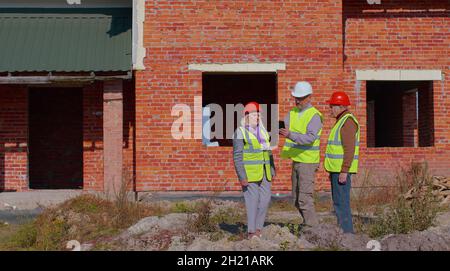 Real estate agent manager architect showing modern house to senior grandparents family client couple Stock Photo